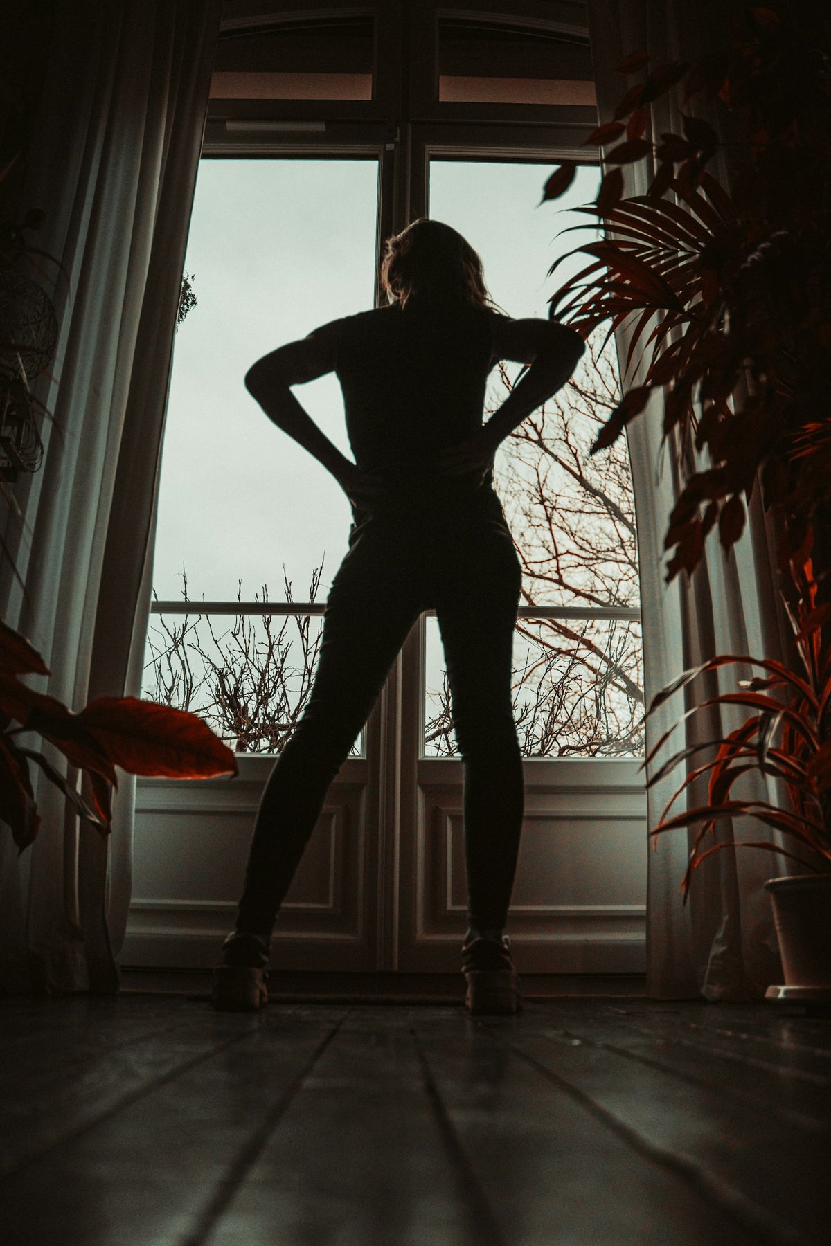 A woman at the window in morning light, ready for the day